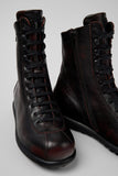 Close-up angled view of Camper Pelotas burgundy leather mid boots showing calfskin texture and signature rubber outsole