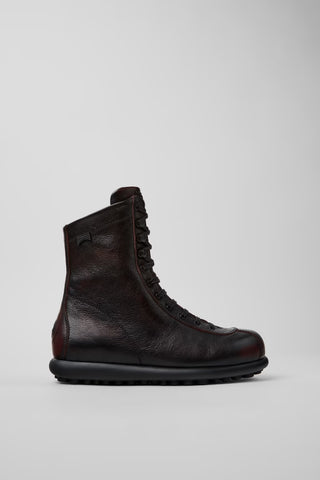 Women’s Camper Pelotas burgundy and black mid boots shown from the side, featuring vegetable-tanned calfskin and 87-sphere rubber sole.