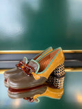 Chie Mihara MUFINI mid heels shown at an angle with olive taupe leather, mustard patent panel, mint edging and amber-toned embellishment