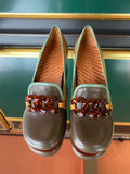 Chie Mihara MUFINI heels viewed from above with olive taupe leather, mustard yellow detail, mint trim and decorative brown resin accent