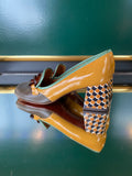 Chie Mihara MUFINI heels shown from the rear angle with a mustard yellow back, mint trim and graphic patterned heel