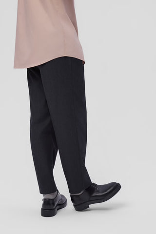 Dean black leather shoes worn with black pants on a plain background