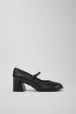 Black leather shoe with a block heel on a light gray background