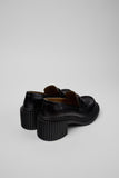 Back view of Camper Pix London black leather moccasin showing heel shape and stitching details on a white background