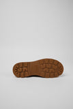 Bottom view of brown nubuck ankle boots showing tread pattern of the XTRAGRIP rubber outsole on a white background