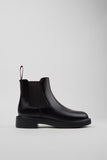 Black Chelsea boot on a light gray background