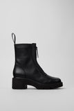 Black leather boot on a light gray background