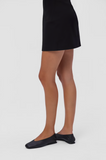 Casi Myra black leather ballerinas styled with a black skirt