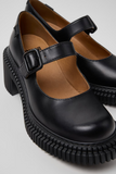 Camper Pix London black leather heeled moccasins with buckle strap and chunky ribbed sole.
