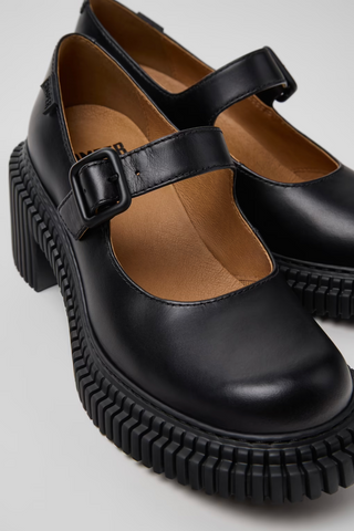 Camper Pix London black leather heeled moccasins with buckle strap and chunky ribbed sole.