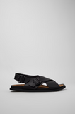 Side view of black Camper Lluc leather sandal with flat rubber outsole.