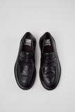 Top view of black Camper Twins leather moccasins with penny-loafer straps, brogue perforations and Camper Twins branding inside.