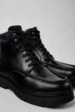 Close-up of Camper Alaro black leather ankle boots showing the leather texture, stitching and sole construction