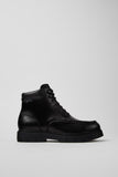 Side view of Camper Alaro men's black leather ankle boots showing the structured upper and substantial rubber sole