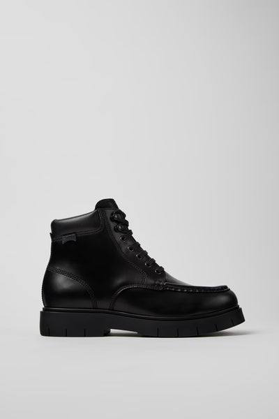 Side view of Camper Alaro men's black leather ankle boots showing the structured upper and substantial rubber sole