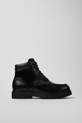 Side view of Camper Alaro men's black leather ankle boots showing the structured upper and substantial rubber sole