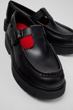 Close-up of Camper Alaro black leather moccasins showing the upper and contrasting design details