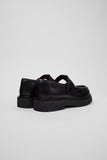 Rear three-quarter view of Camper Alaro black leather moccasins showing the heel and rubber sole