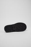 Underside of Camper Alaro black leather moccasins showing the rubber outsole and tread pattern