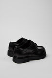 Rear three-quarter view of Camper Alaro men's black leather shoes showing the heel and rubber sole profile