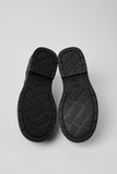 Underside of Camper Alaro black leather shoes showing the BRIDGE XTRAGRIP rubber outsole and tread pattern