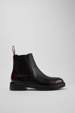 Side view of Camper Dean men's black and burgundy leather ankle boots showing the Chelsea-style silhouette and low heel