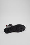 Underside of Camper Dean black and burgundy leather ankle boots showing the outsole and tread pattern