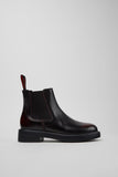 Side view of Camper Dean black and burgundy leather ankle boots showing the ankle-height silhouette