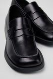 Close-up of Camper Donna black calfskin loafers showing the leather upper and penny loafer detailing