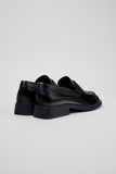 Rear three-quarter view of Camper Donna black leather loafers showing the heel and sole profile
