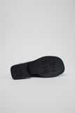 Underside of Camper Donna black leather loafers showing the outsole design