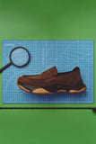 Camper Karst 2 brown suede moccasin displayed against a colourful blue and green editorial background