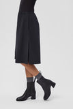 Camper Kora black leather ankle boots worn on foot, showing their ankle-height shape and block heels