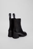 Rear view of Camper Kora black leather ankle boots showing the sculptural heels and ankle shafts