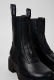 Camper Milah black leather ankle boots worn on foot, showing their shape and proportions