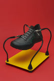 Camper Peu Serra grey sneakers featured in a colourful editorial image with a bright red and yellow background
