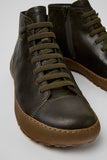 Close-up of Camper Peu Serra green leather ankle boots showing the elastic laces, leather texture and stitching