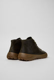 Rear three-quarter view of Camper Peu Serra green leather ankle boots showing the ankle shafts and rubber sole