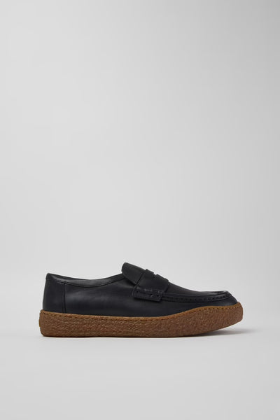 Side view of Camper Peu Terreno men's black leather moccasins showing the brown crepe rubber sole and relaxed silhouette