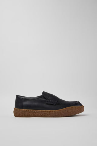 Side view of Camper Peu Terreno men's black leather moccasins showing the brown crepe rubber sole and relaxed silhouette
