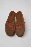 Underside of Camper Peu Terreno black leather moccasins showing the crepe rubber outsole and tread pattern