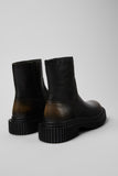 Rear three-quarter view of Camper Pix Berlin black and brown leather ankle boots showing the heel and sole profile