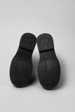Underside of Camper Pix Berlin black and brown leather ankle boots showing the outsole and tread pattern