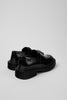 Rear three-quarter view of Camper Pix Berlin black leather loafers showing the heel and sole profile