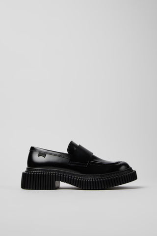 Side view of Camper Pix Berlin black leather loafers showing their structured silhouette and low heel