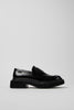 Side view of Camper Pix Berlin black leather loafers showing their structured silhouette and low heel