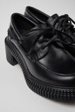 Close-up of Camper Pix London black leather heeled loafers showing the leather upper and distinctive detailing