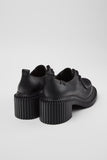 Rear three-quarter view of Camper Pix London black leather heeled shoes showing the heel and back profile

 Afrita alla 5 myndatextana