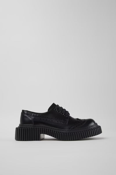 Side view of Camper Twins black leather shoes showing their contemporary silhouette and sculptural sole