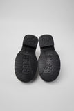 Underside of Camper Twins black leather shoes showing the outsole design